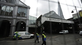 Security marshals are seen through a fence walking beside Borough market, in London, which remains closed to the public after the attack that took place there, Monday, June 12, 2017. (Matt Dunham/AP)