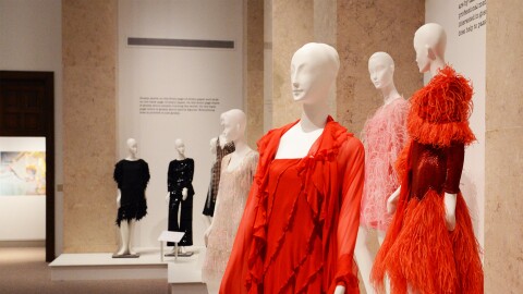 Red and black dresses on mannequins in a museum gallery