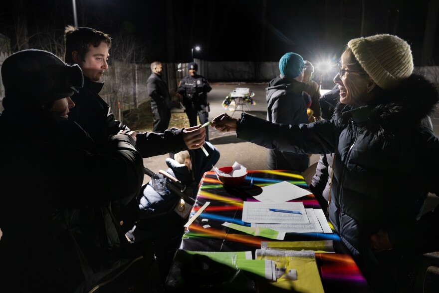 With a security official and a West Hartford Police Department officer in the background, Amalya Lehmann, Ariel Weiss are greeted by Cindi Goldman while entering “The Great Glow” at Young Israel of West Hartford. Held on the fourth day of Chanukah, the event included lighting a menorah, a glow party and a dreidel competition. “Chanukah is our age-old reminder that light truly triumphs over the darkness,” said Rabbi Tuvia Brander, Rabbi of Young Israel of West Hartford. “At a moment when many are searching for connection and reassurance, this gathering is about standing together—families, neighbors, and friends—and choosing to bring light into the public square.”