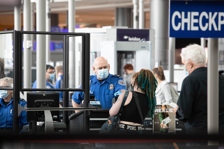 A TSA agent checks a passenger's ID at Austin-Bergstrom International Airport.