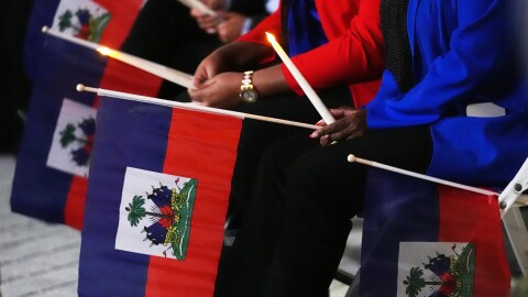 People hold Haitian flags and candles during a vigil at the Little Haiti Cultural Complex in North Miami after a federal judge blocked the Trump administration from ending TPS for Haitians, Tuesday, Feb. 3, 2026.