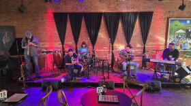 musicians on stage at UrbanBeat including a guitar player, a bass player, a piano player, a soporano saxophone player and a drummer.