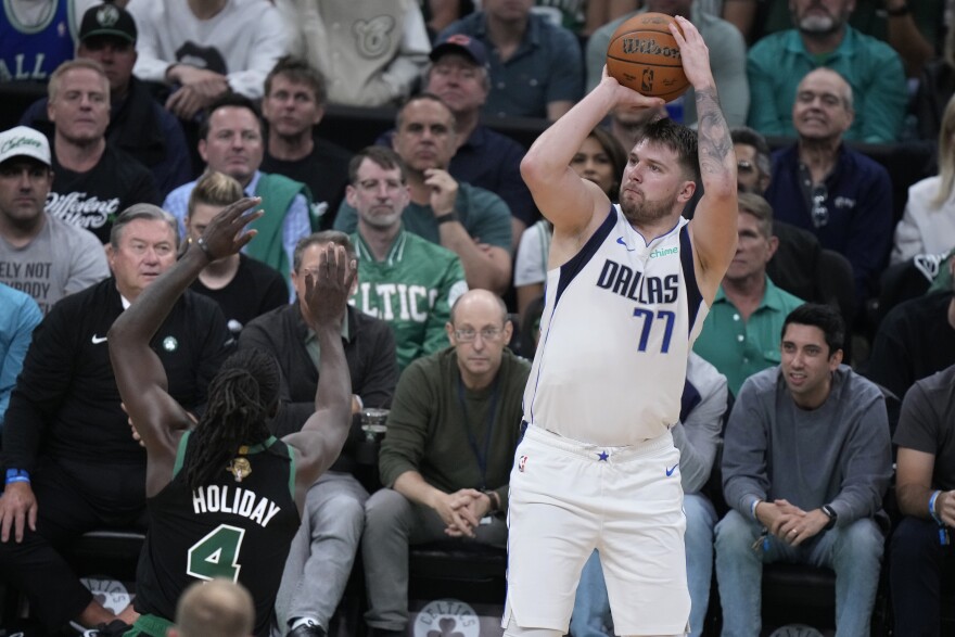 Dallas Mavericks guard Luka Doncic (77) looks to shoot over Boston Celtics guard Jrue Holiday (4) during the first half of Game 2 of the NBA Finals basketball series, Sunday, June 9, 2024, in Boston.