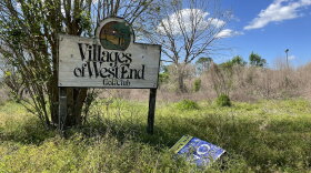 An old sign at the former golf course off Newberry Road is surrounded by overgrown grass and weeds. (Photo Aileyahu Shanes/WUFT News)
