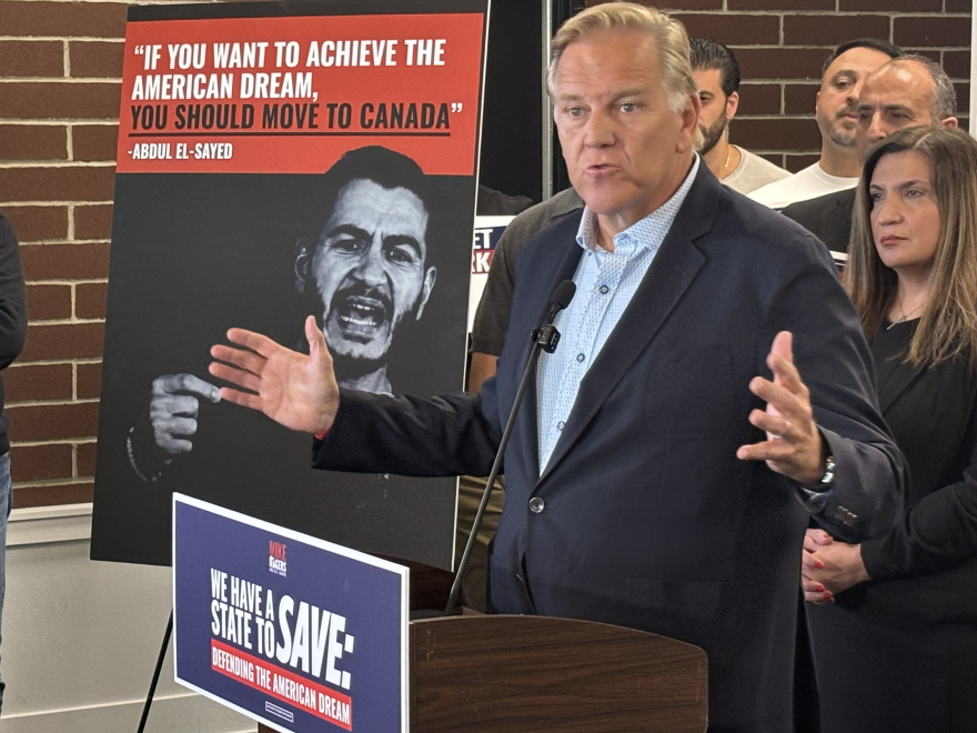 Republican U.S. Senate candidate Mike Rogers speaks at a lectern, gesturing with both hands.