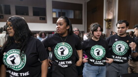 Advocates for a union for Starbucks employees watch as Starbucks founder Howard Schultz leaves the hearing room after testifying to the Senate Health, Education, Labor and Pensions Committee about whether he tried to interfere with an ongoing unionizing campaign, at the Capitol in Washington, Wednesday, March 29, 2023.