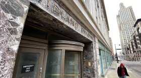 A man walks past the revolving door entrance to the currently shuttered Midland Building at 13th and Baltimore where the Cordish Company plans to remodel the office space as an affordable housing project.