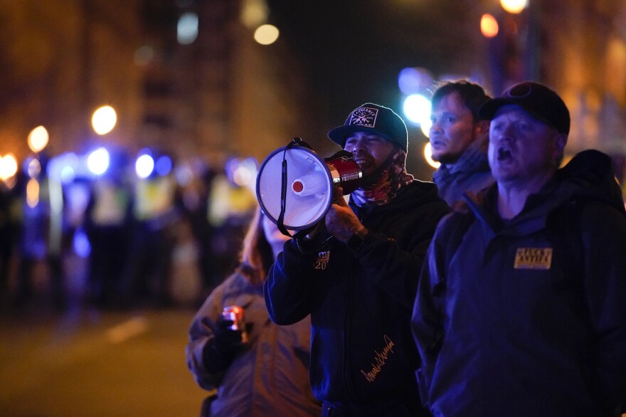 People yell as a police line tries to clear those violating curfew outside a JW Marriott in Washington, D.C. on Wednesday night.