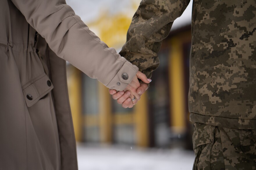 Inna Yermolovych holds hands with her husband at the train station.