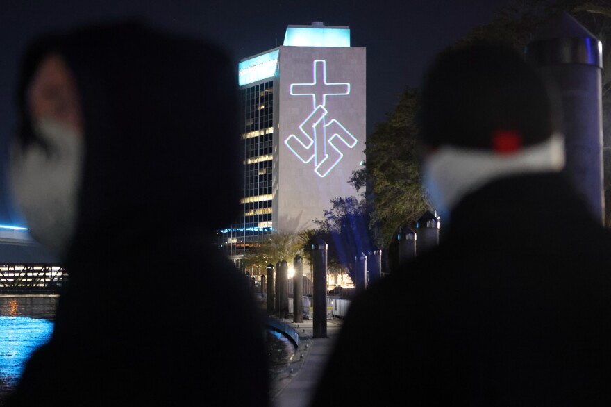 Members of the white nationalist group National Socialist Florida use a laser projector to display white nationalist and anti-LGBTQ images on the side of the CSX building and other high-rise buildings in Jacksonville, Fla.