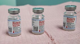 Three nearly empty bottles of the Moderna COVID-19 vaccine which can not be mixed to provide an addition dose for a vaccination shot. (Jesse Costa/WBUR)