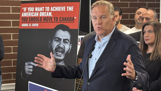 Republican U.S. Senate candidate Mike Rogers speaks at a lectern, gesturing with both hands.