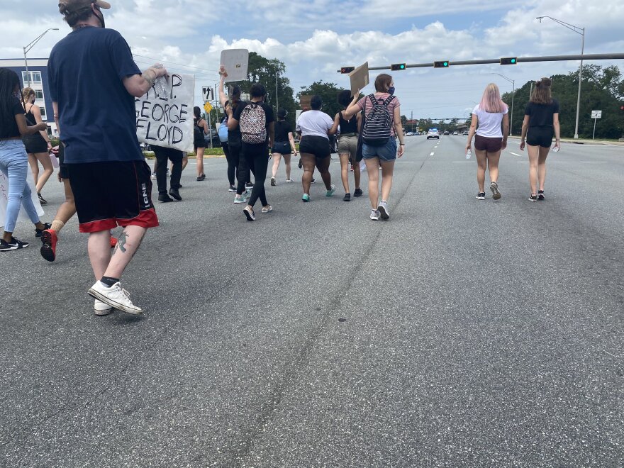 People march on Tallahassee’s north side. The group went all the way from midtown to here, up Thomasville Road, crossing under I-10. One of the busiest intersections in town in the afternoons came to a standstill as they passed