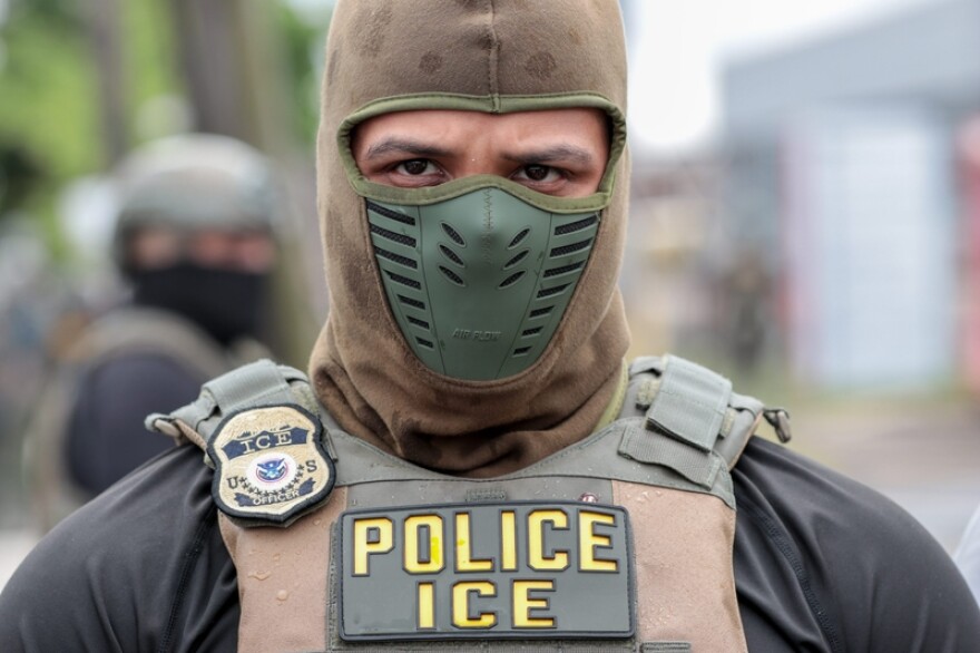 A U.S. Immigration and Customs Enforcement officer watches a crowd of protesters at Delaney Hall, a detention center, in Newark, New Jersey, on May 25, 2026. Employing new tactics, ICE arrested more people in July than in any previous month of the Trump administration.