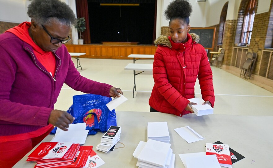 Toni Mathis, left, and Aniyah Taylor assemble greeting cards to give out for Valentine's Day.