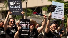 People carrying signs opposed to a ban on transgender people serving in the U.S. military participate in the Washington Pride parade, Saturday, June 20, 2026, in Washington.