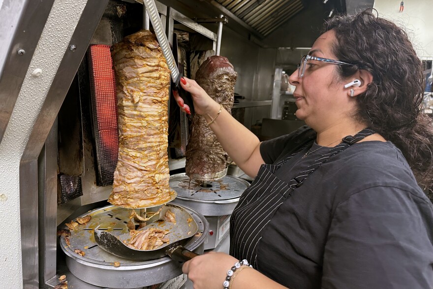 Reem Hadir, Executive Chef and founder of Lebnani Mediterranean Kitchen and Bar slicing chicken shawarma in Watertown, Connecticut.