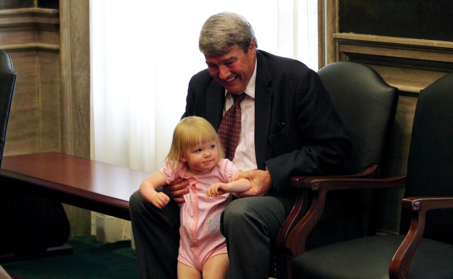 Mark Richardson holds his granddaughter, Briley, during his son's end-of-session press conference. 