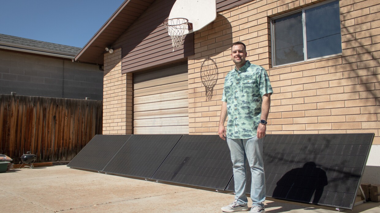 Alex Giesey stands in front of his backyard solar panels in West Jordan, March 20, 2026