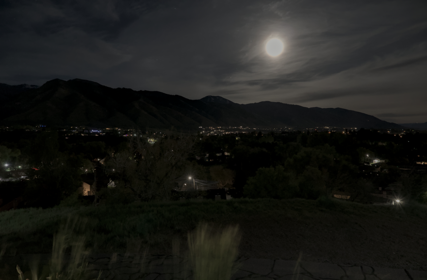 City lights and a full moon on a dark and cloudy night. 