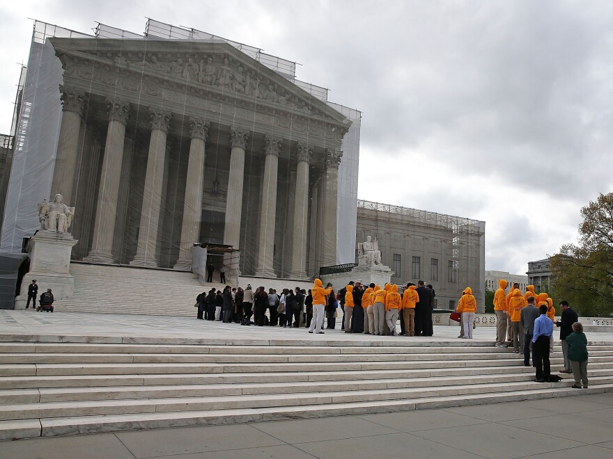 People line up to enter the Supreme Court on Monday for arguments.