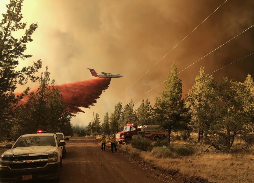 A firefighting tanker aircraft making a fire retardant drop over the Grandview Fire in 2021