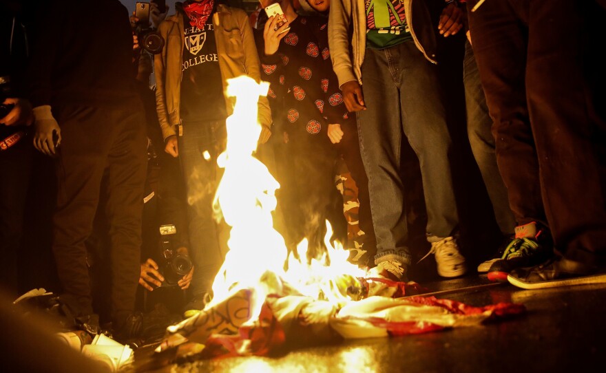 Protestors burn an American flag outside of Trump Tower in New York City on Wednesday.