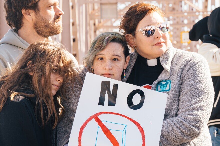 The Rev. Katie Nix, lead pastor at Grace United Methodist Church in University City, right, embraces her daughter Elizabeth Nix, center, and Allison Brodie, left, while rallying against ICE alongside hundreds of faith leaders and community members on Feb. 16 in downtown St. Louis.