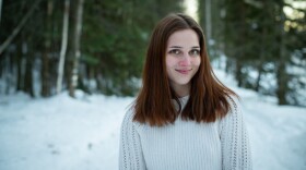 a portrait of a woman in a sweater outside