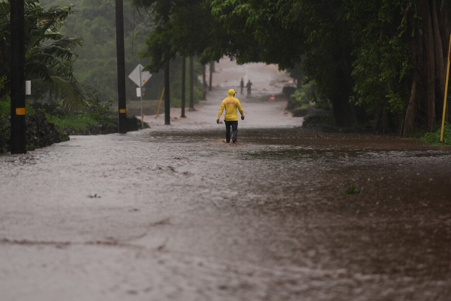 Fire Captain Lui Sales of the Hawaiʻi Fire Department looks for residents to help as rainwater from nearby Hurricane Nolo flood a section of Māmalahoa Highway Saturday, Sept. 26, 2026, near Nāʻālehu, Hawaiʻi.