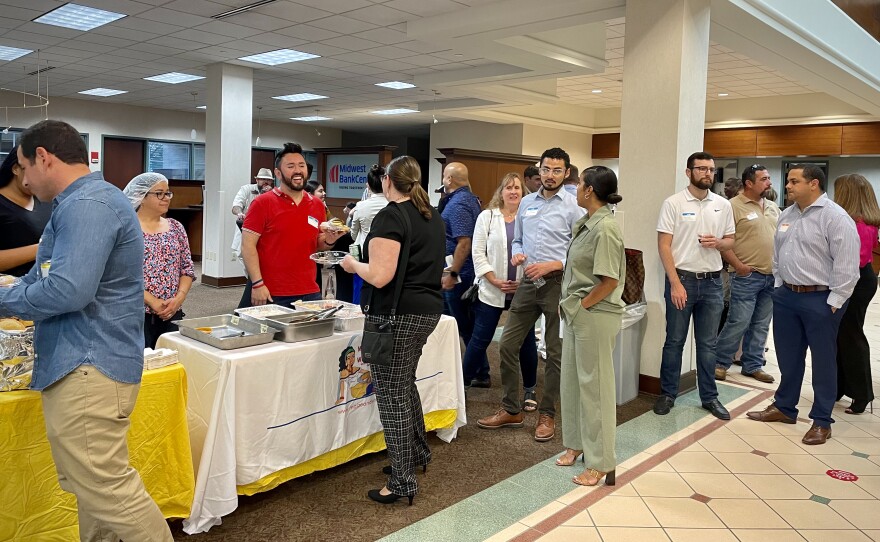 Bañuelos Serrano (center left, in red) stands in line for empanadas at the Business After Hours event on Thursday, Sept. 15, 2022.