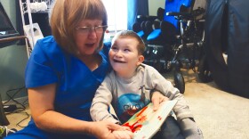 Home health nurse Rita Nuss reads a book to 9-year-old Josiah Melton, who has  chromosomal disorders and is on the developmental disabilities services waiting list.