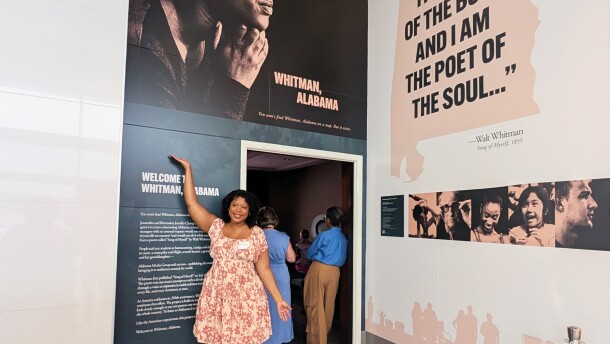 Curtia Torbert, a film participant whose image illustrates signs for the airport exhibit, poses in front of the theater during the opening reception