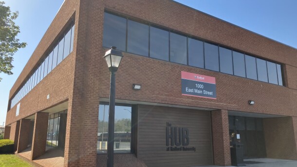 A brown brick building  that has the words "The Hub at Radford University" written in black letters.