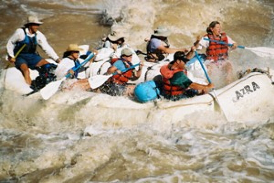A group paddles through a white-water rapid in Grand Canyon.