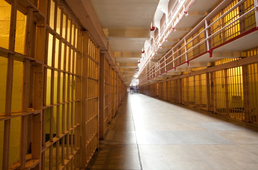 A photo of a hallway with cells down the sides