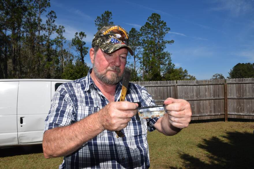 "This is a beetle blaster," he said. "Beetles fall into the oil and get stuck." The blaster protects the bees from one of their main pests. (Brooke Henderson/WUFT News)