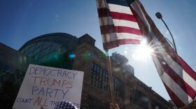 Donny Wadkins holds a US flag outside the Pennsylvania Convention Center as ballot counting in the presidential election continues inside in Philadelphia.