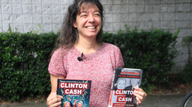Ann Lhota, of Newberry, Florida, holds up the book and graphic-novel versions of "Clinton Cash" outside Alachua County's Newberry library on Monday. Lhota said she's upset by the county library system's refusal to purchase the graphic novel. (Cecilia Mazanec/WUFT News)