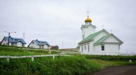 A white wooden church with a golden onion dome