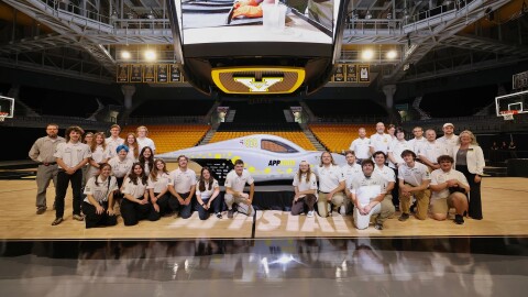 a team of students in front of a new solar car they built