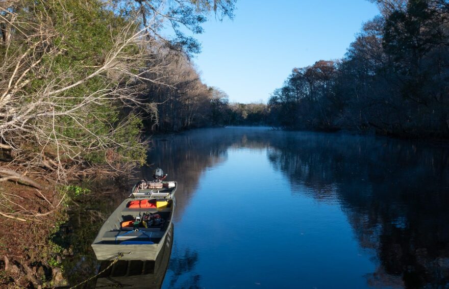 A boat in the water to the left of the river