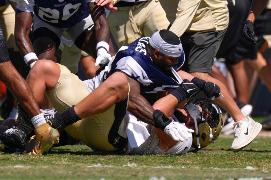 Dallas Cowboys outside linebacker Sam Williams, top, fight with New Orleans Saints tight end Moliki Matavao during an NFL football joint practice, Tuesday, Aug. 18, 2026, in Oxnard, Calif.