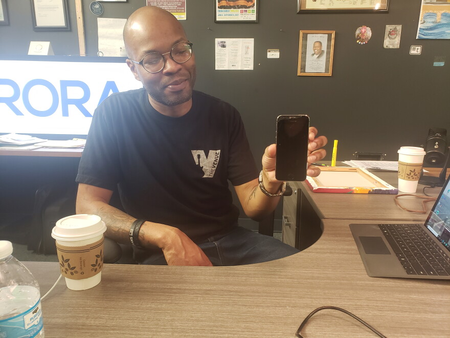 Spivey showing off the phone that helped start Good Morning Aurora