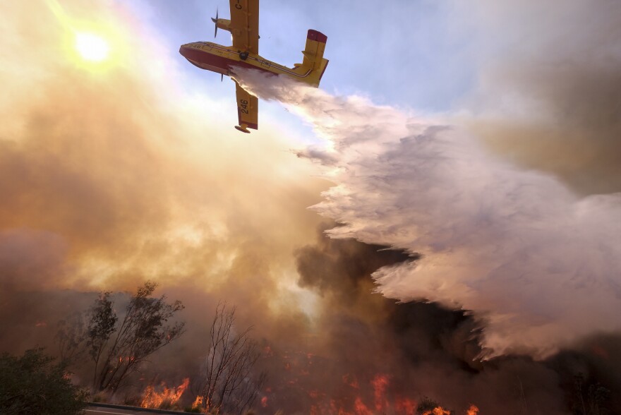 An air tanker drops water on a fire along the Ronald Reagan Freeway in Simi Valley, Calif.