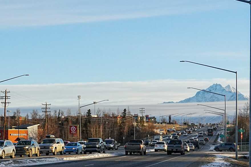 Moderate traffic on a four-lane highway with Denali in the background