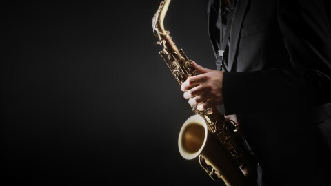 Saxophone player. Saxophonist hands playing saxophone. Alto sax player with classical music instrument closeup