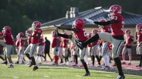 Football players from a Mississippi high school warm up before practice. There are new recommendations to get big linemen safe during hot weather workouts.
