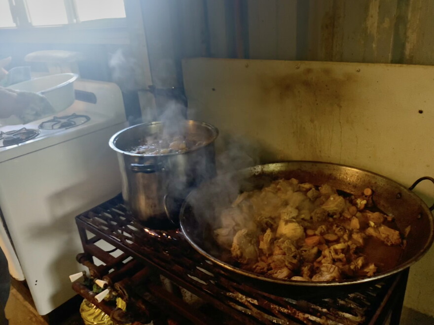 Volunteer Jesse Denny cooks chicken and vegetables for a free hot community lunch at the Nāʻālehu Resilience Hub on Oct. 1, 2026. Denny grows produce for the hub's meals, including the carrots in that day's stew.