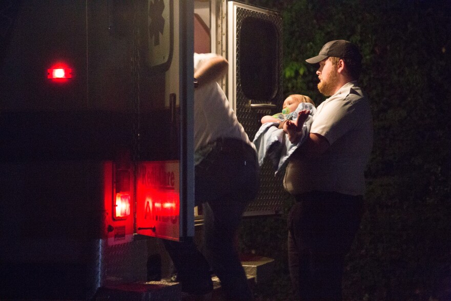 Paramedics settle a one-year-old boy into an ambulance after the child was carried over a huge mudslide outside Richwood, WV.